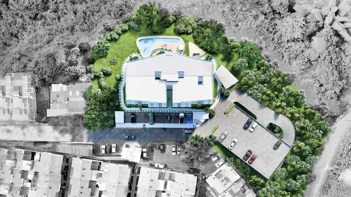 Vista aérea de la implantación: torre al centro, piscina y jardines atrás, parqueaderos a un costado